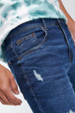 Jean azul intenso tipo carrot con botas cortas y rotos en frente
