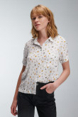 Blusa unicolor con cuello camisero y estampados femeninos