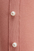 Camiseta unicolor manga larga, con cuello alto y perlas sobre manga.