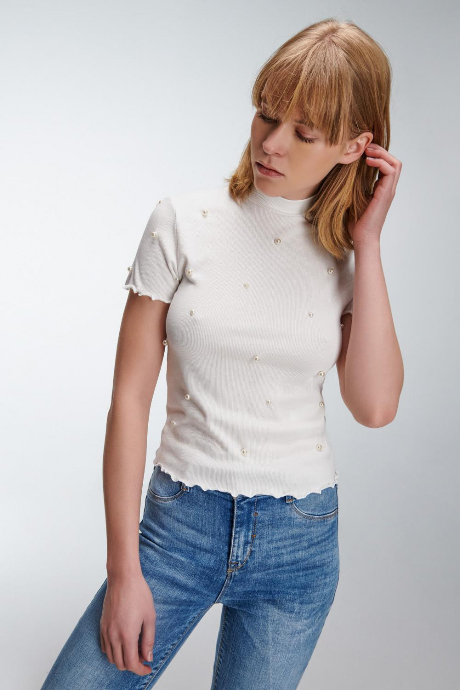 Camiseta femenina unicolor con perlas sobre frente y mangas.