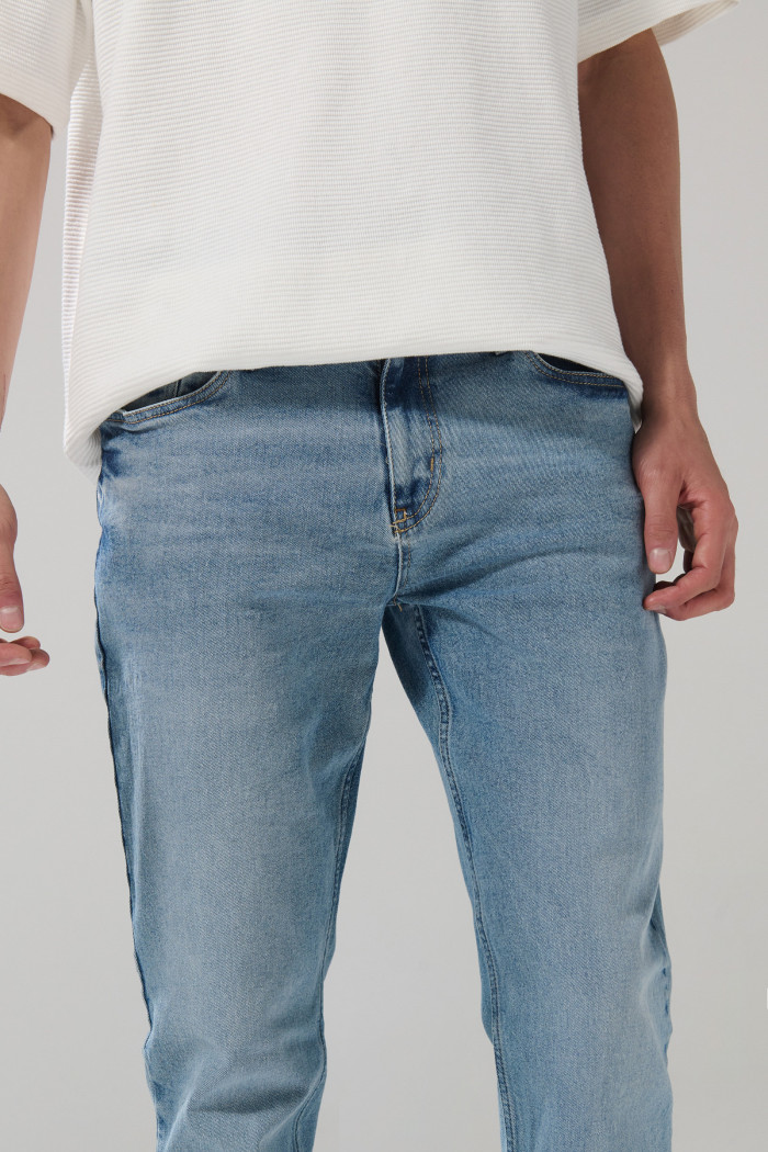 Jean azul claro slim con desgastes ligeros y tiro bajo