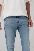 Jean azul claro slim con desgastes ligeros y tiro bajo