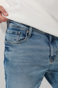 Jean azul claro slim con desgastes ligeros y tiro bajo