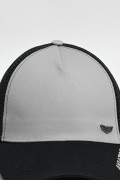 Cachucha trucker negra con corte gris y texto delantero

