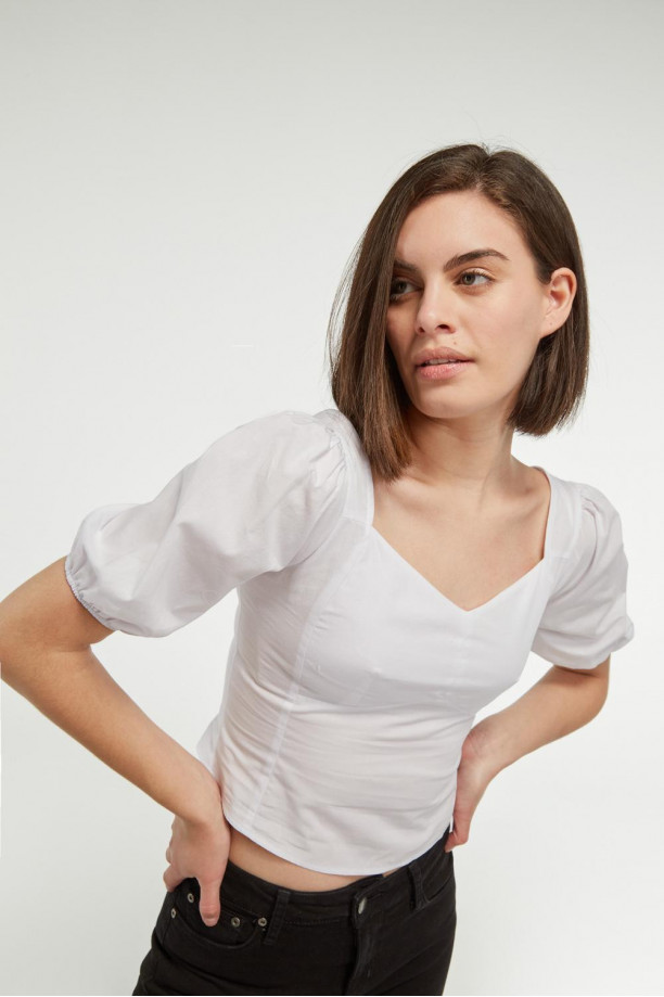 Blusa blanca escotada con mangas cortas aglobadas y cortes
