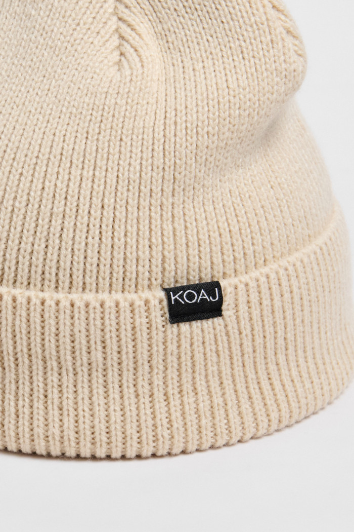 Gorro unicolor tejido con marquilla en frente y doblez
