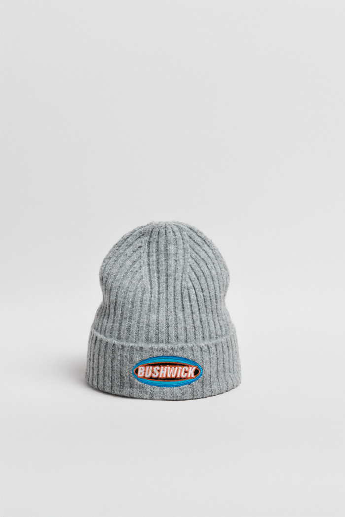 Gorro tejido unicolor con texto en frente y finas texturas
