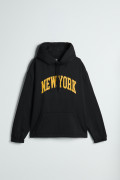 Buzo negro con capota oversize y texto college en frente
