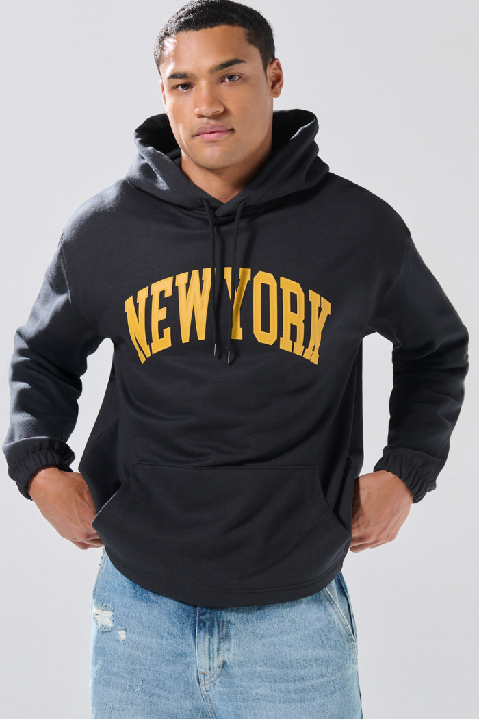 Buzo negro con capota oversize y texto college en frente
