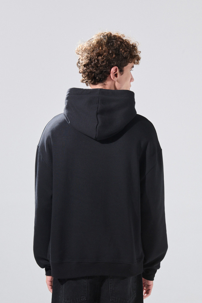 Buzo oversize negro con capota y texto rojo college
