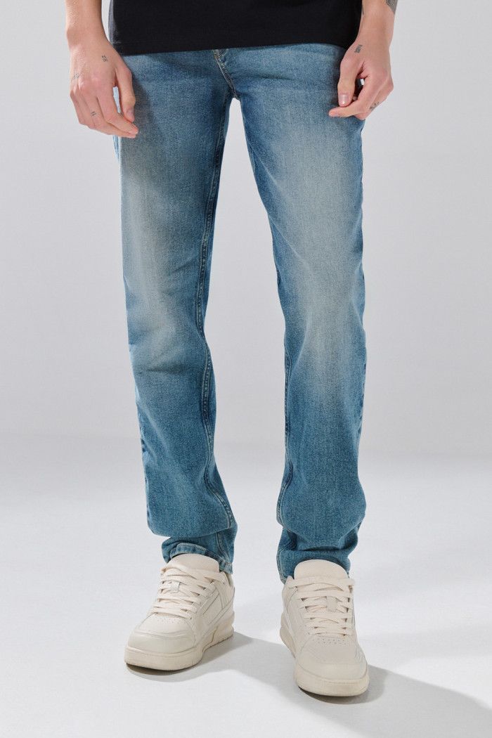 Jean slim infaltables azul medio con ligeros desgastes
