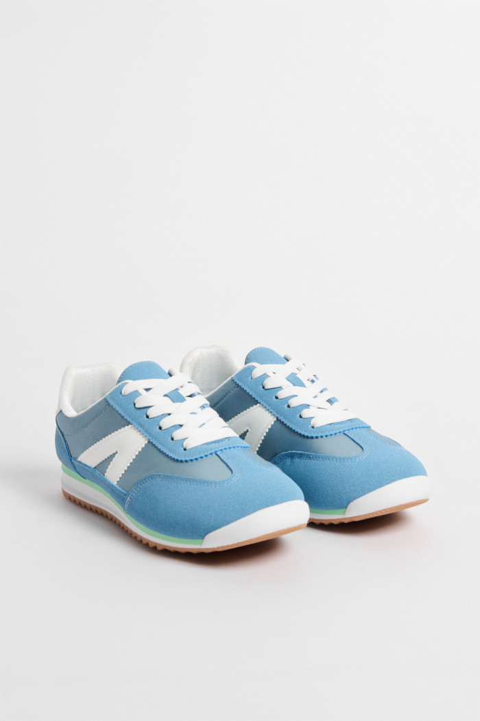 Tenis casuales unicolores con diseños laterales en contraste
