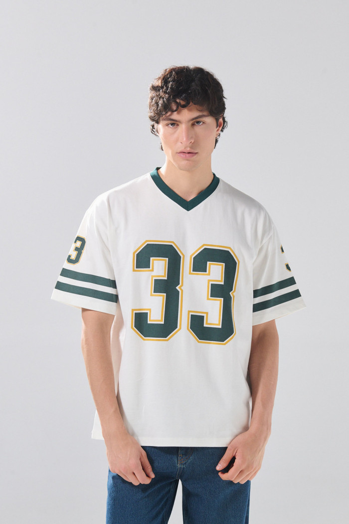 Camiseta crema cuello V oversize con artes college numéricos

