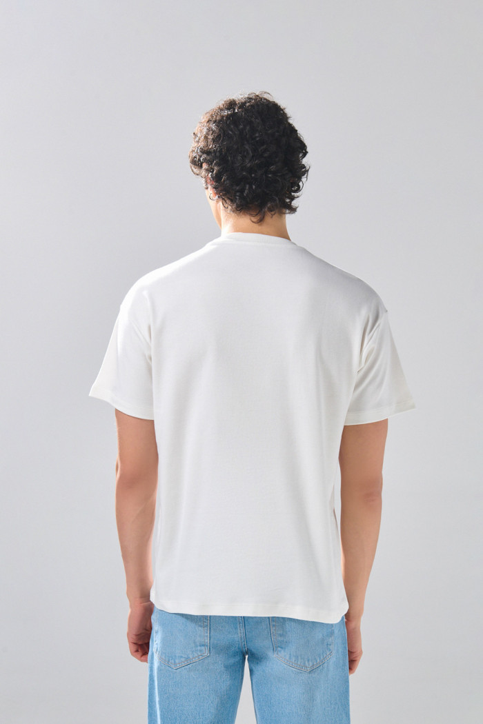 Camiseta cuello redondo crema con diseño college deportivo
