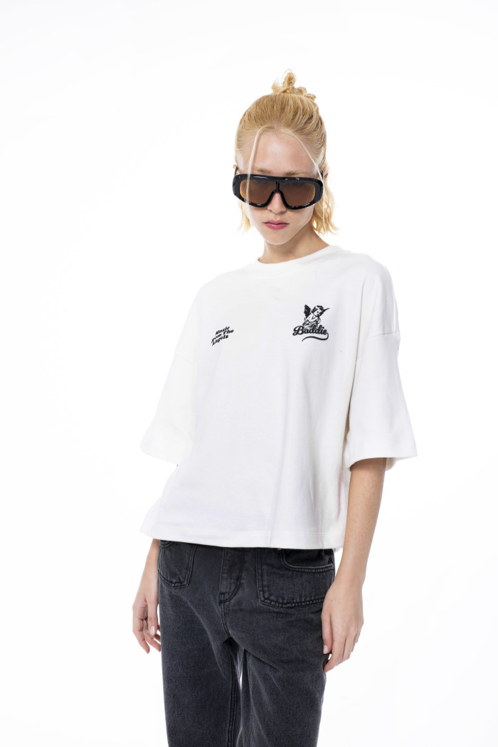 Camiseta crema crop top oversize con diseño en frente

