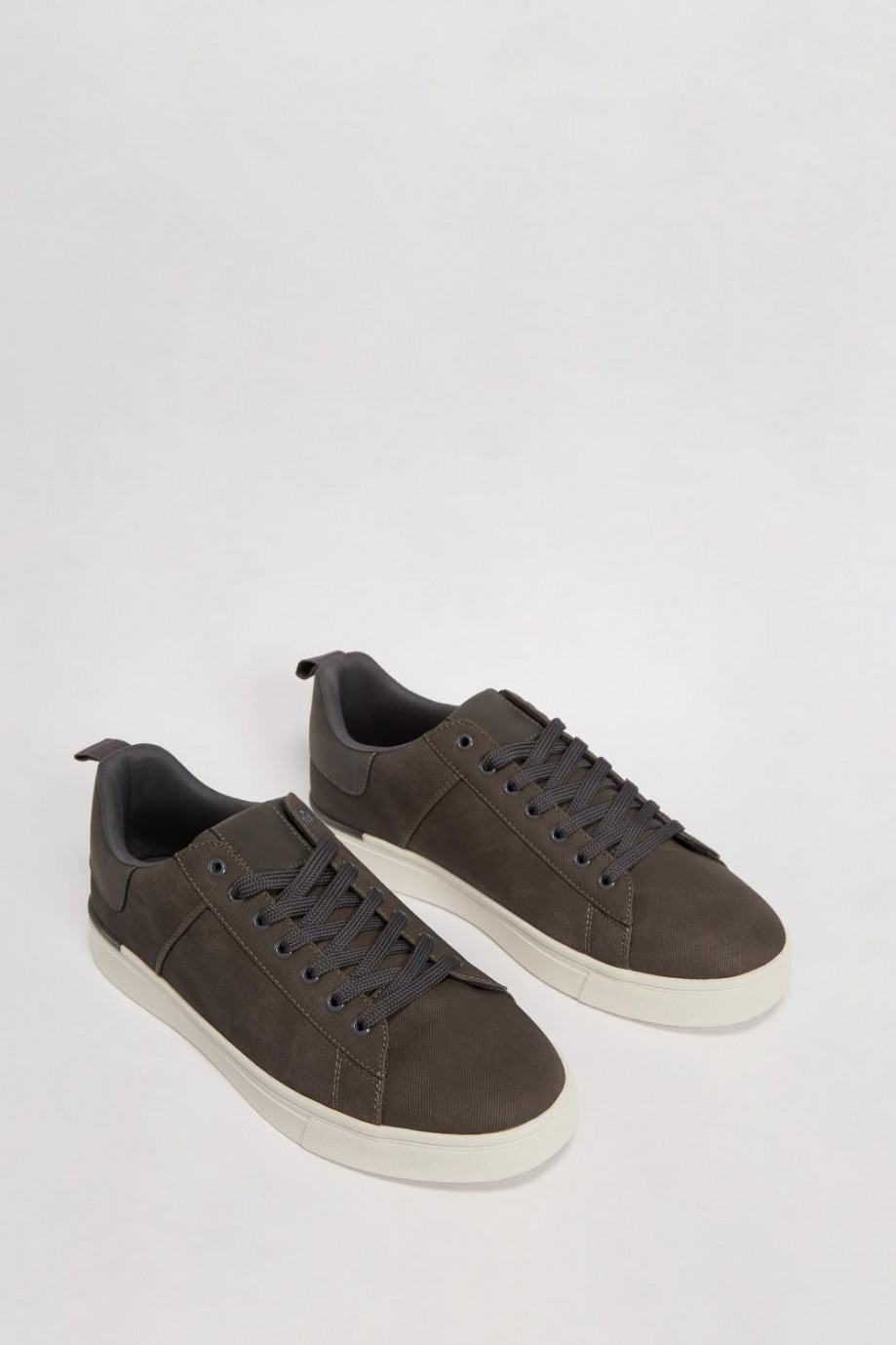 Tenis planos unicolores con costuras decorativas localizadas