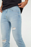 Jean slim azul claro con rotos en frente y tiro bajo