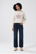 Buzo oversize crema con capota y texto college en frente
