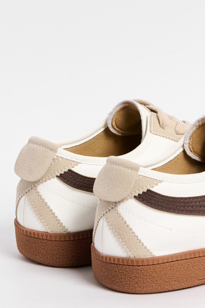 Tenis unicolores casuales con diseños negros y cortes
