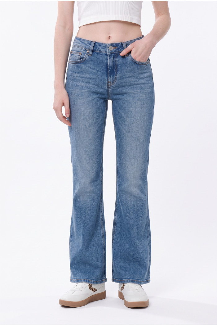 Jean flare azul medio con bota ancha, desgastes y bolsillos

