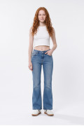 Jean flare azul medio con bota ancha, desgastes y bolsillos
