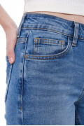 Jean flare azul medio con bota ancha, desgastes y bolsillos
