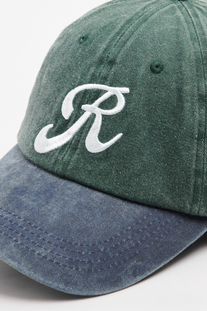 Gorra beisbolera color verde sin refuerzo, sistema de cierre trabilla y con bordado de "R".