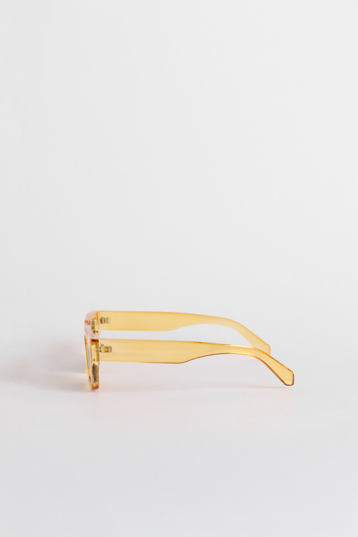 Gafas de sol de marco rectangular elaboradas en pasta amarilla y lentes oscuros.