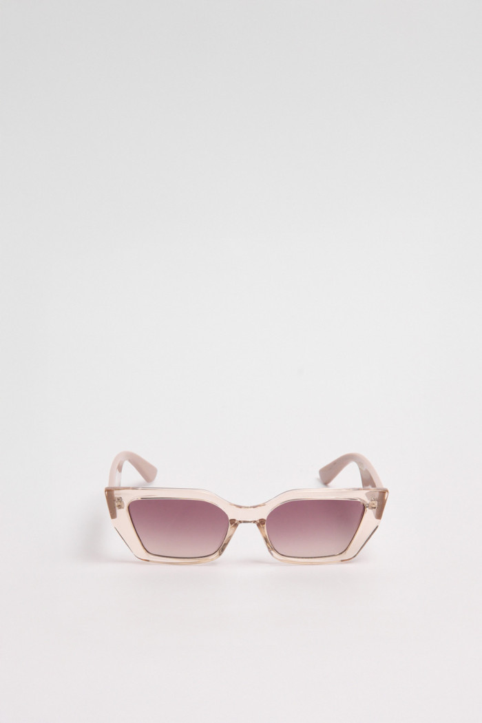 Gafas de sol con marco rectangular crema y lentes esfumados en contraste.