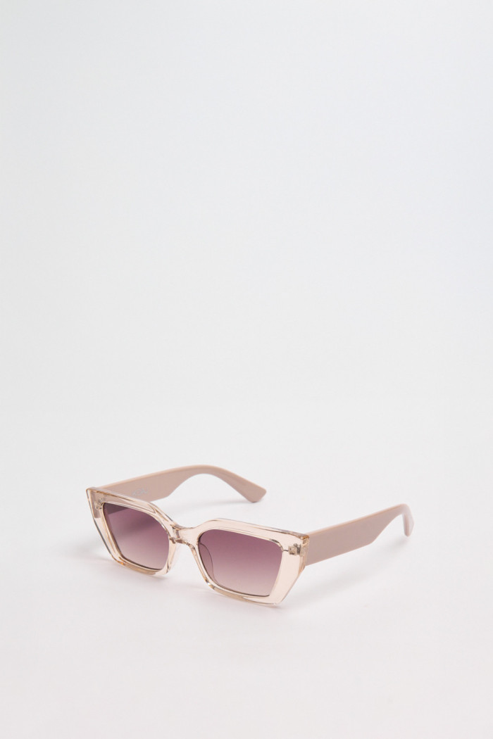 Gafas de sol con marco rectangular crema y lentes esfumados en contraste.