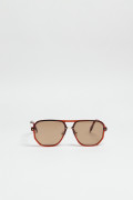 Gafas de sol con marco rectangular café y lentes esfumados en contraste.