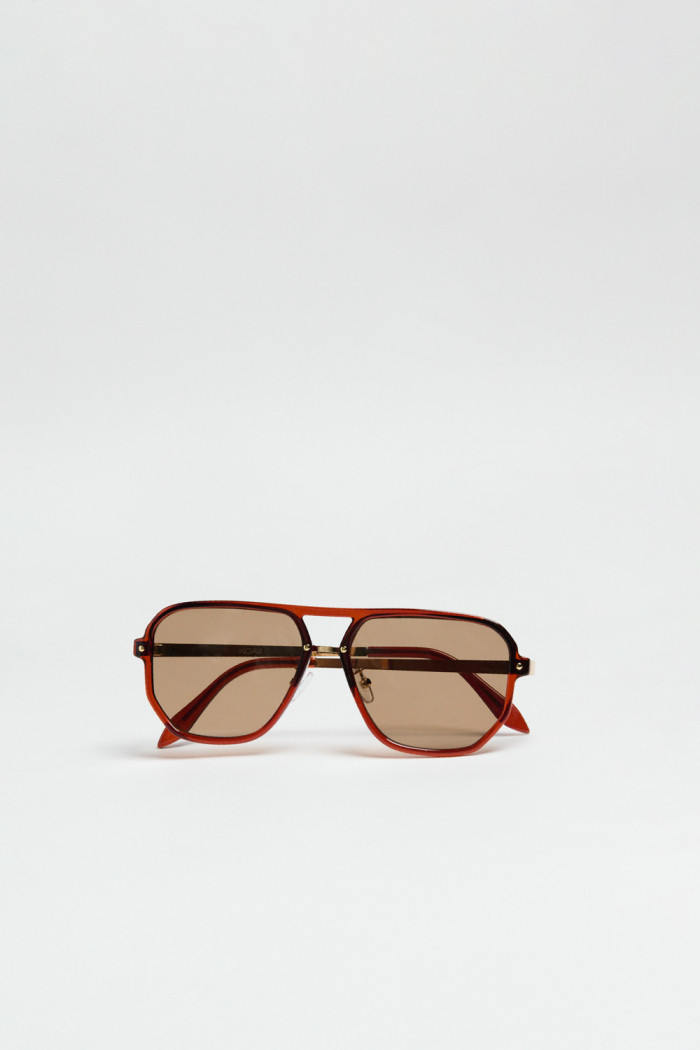 Gafas de sol con marco rectangular café y lentes esfumados en contraste.