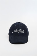 Gorra beisbolera en color azul, con refuerzo, cierre plástico y aplique bordado "New York".