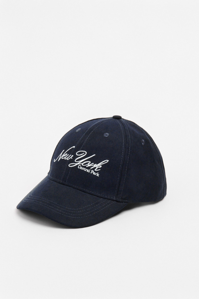 Gorra beisbolera en color azul, con refuerzo, cierre plástico y aplique bordado "New York".