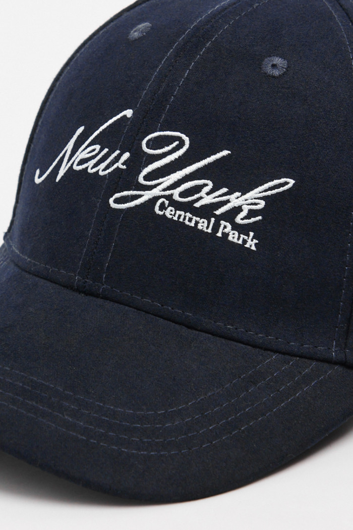Gorra beisbolera en color azul, con refuerzo, cierre plástico y aplique bordado "New York".
