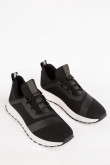 Tenis deportivos negros con materiales y suelas en contraste