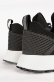 Tenis deportivos negros con materiales y suelas en contraste