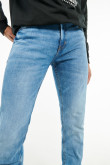Jean tiro bajo tipo slim azul medio con desgastes sutiles de color