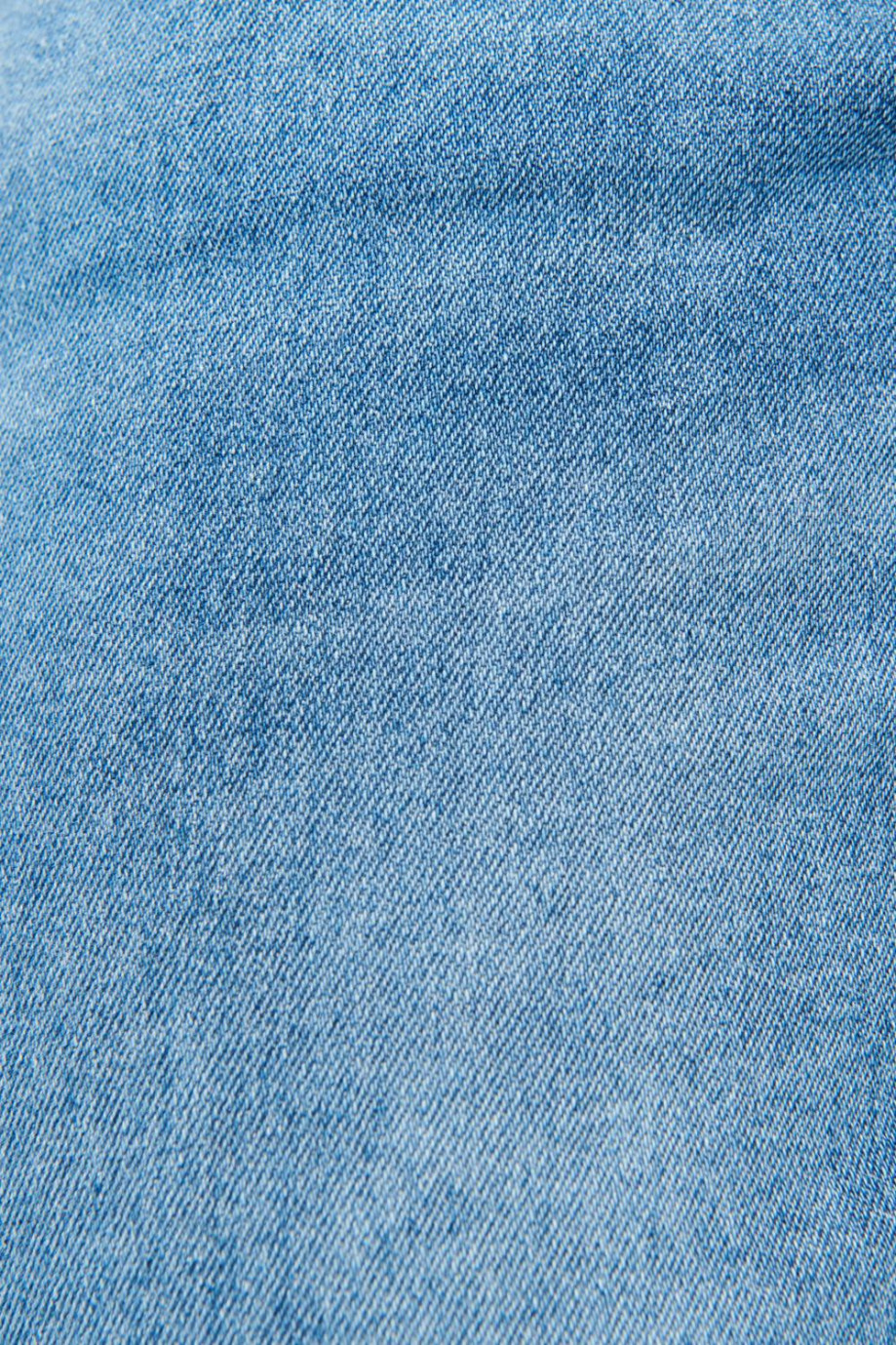 Jean tiro bajo tipo slim azul medio con desgastes sutiles de color