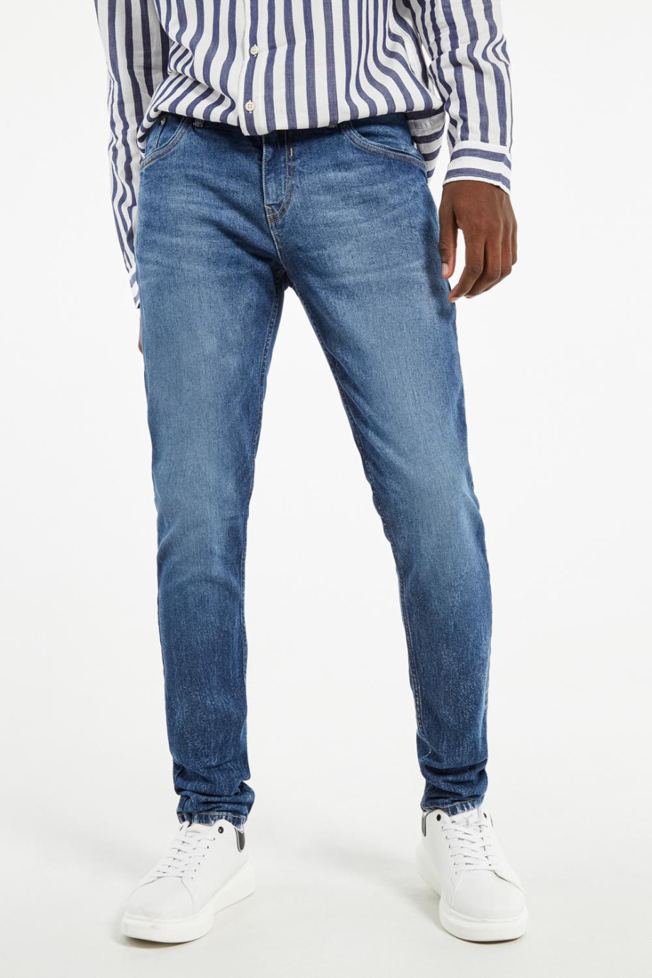 Jean azul oscuro tipo skinny con 5 bolsillos y desgastes de color
