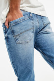 Jean azul medio tipo skinny con tiro bajo y desgastes de color