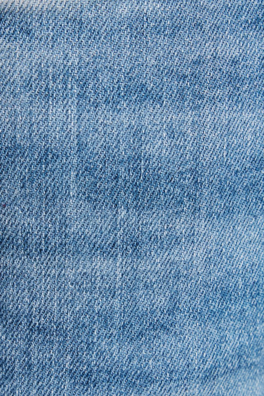 Jean azul medio tipo skinny con tiro bajo y desgastes de color