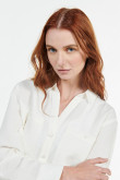 Blusa unicolor con cuello camisero y bolsillos en frente