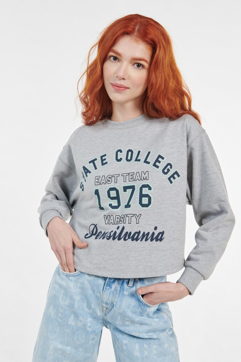 Buzo crop top gris claro con cuello redondo y estampado college