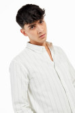 Camisa con cuello button down manga larga con diferentes tonos de rayas y botonadura en el frente.