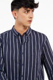 Camisa con cuello button down manga larga con diferentes tonos de rayas y botonadura en el frente.