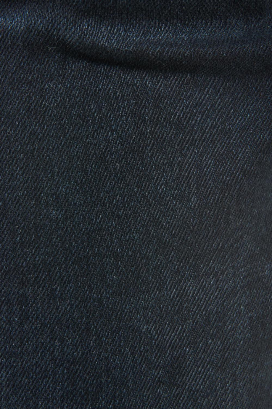Jean slim azul intenso con costuras cafés, tiro bajo y ajuste ceñido
