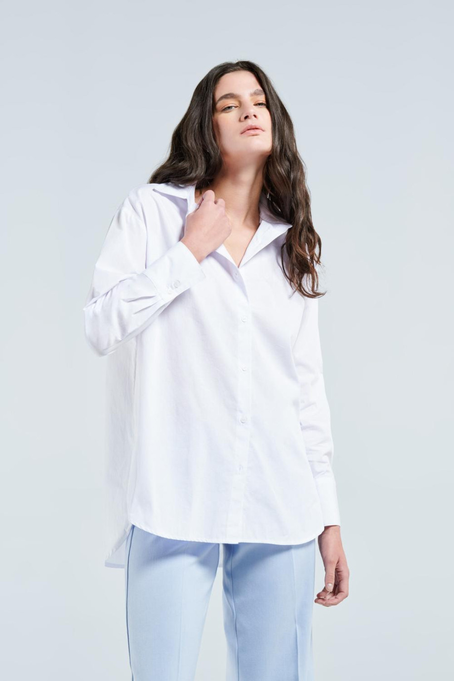 Blusa blanca con manga larga, cuello camisero y botones en frente