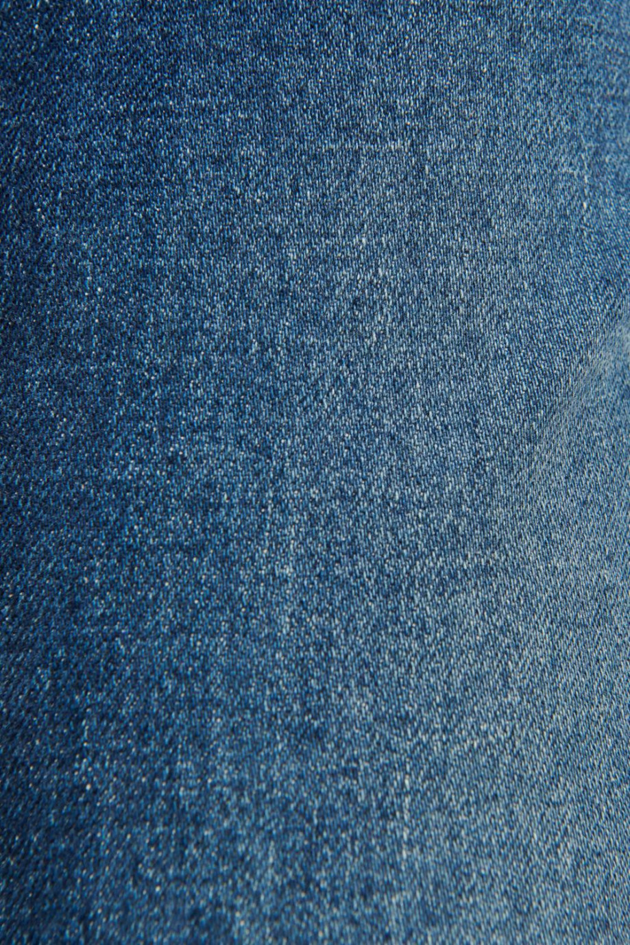 Jean slim azul oscuro con tiro bajo y desgastes sutiles de color