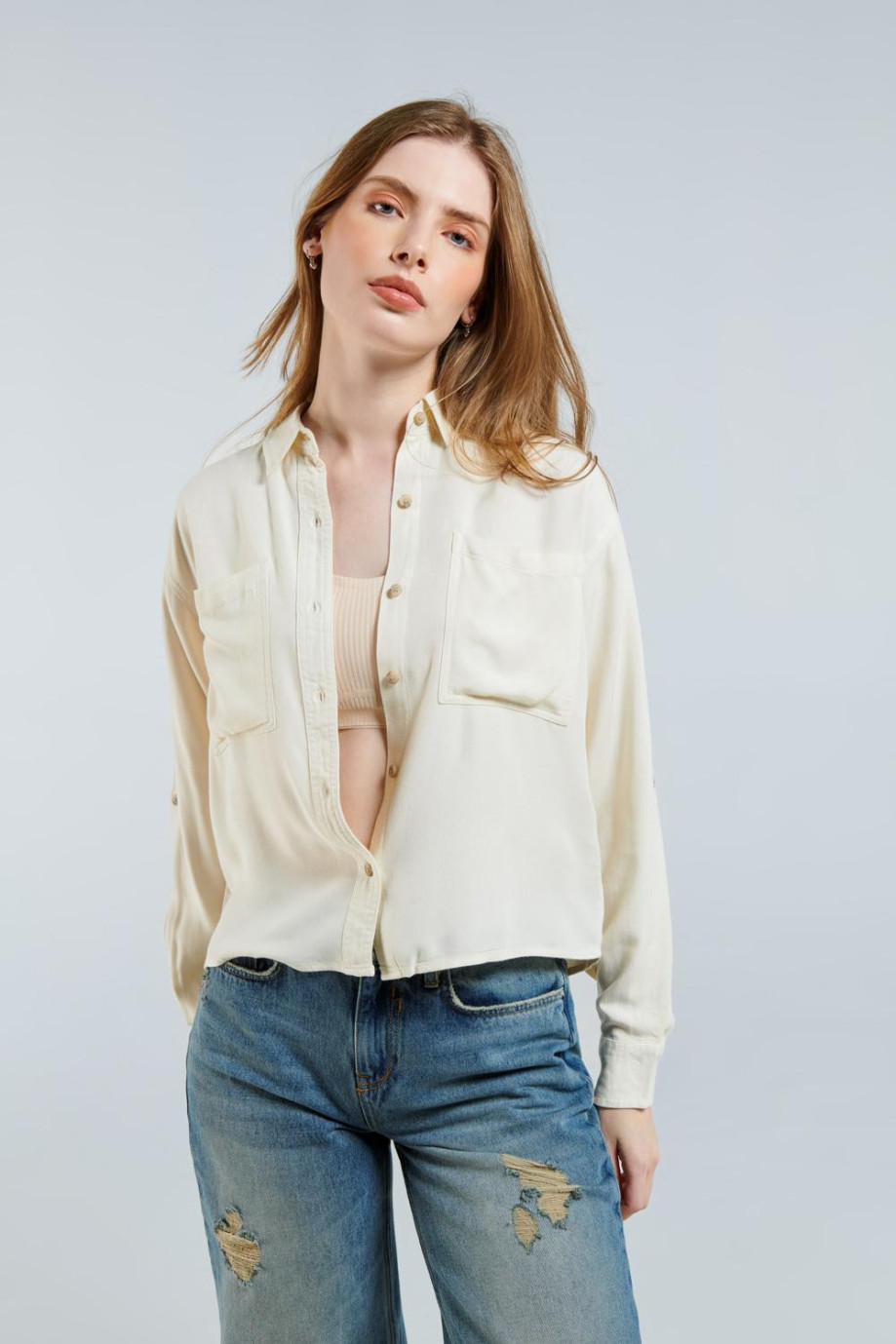 Blusa unicolor manga larga con doble bolsillo y cuello camisero